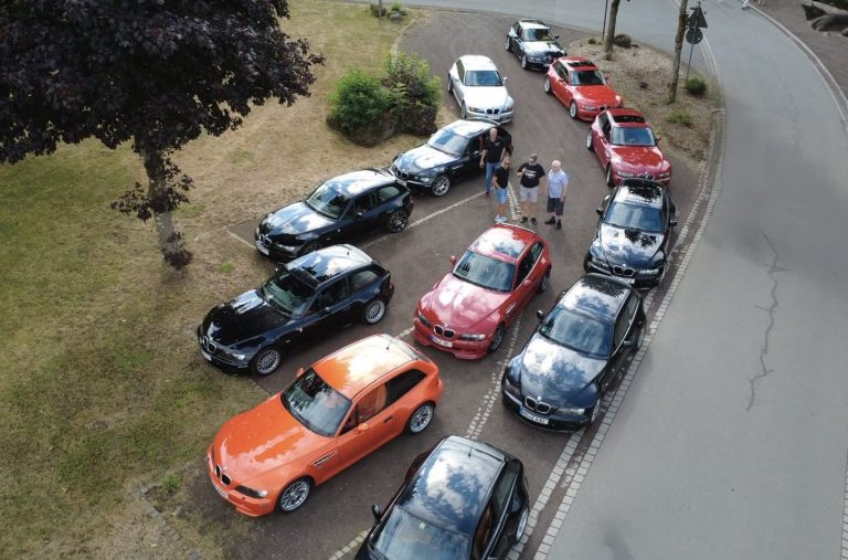 Drohnenaufnahme Mehrere Z3 Coupé parken entlang einer Straße, dazu stehen Personen zwischen den Fahrzeugen.